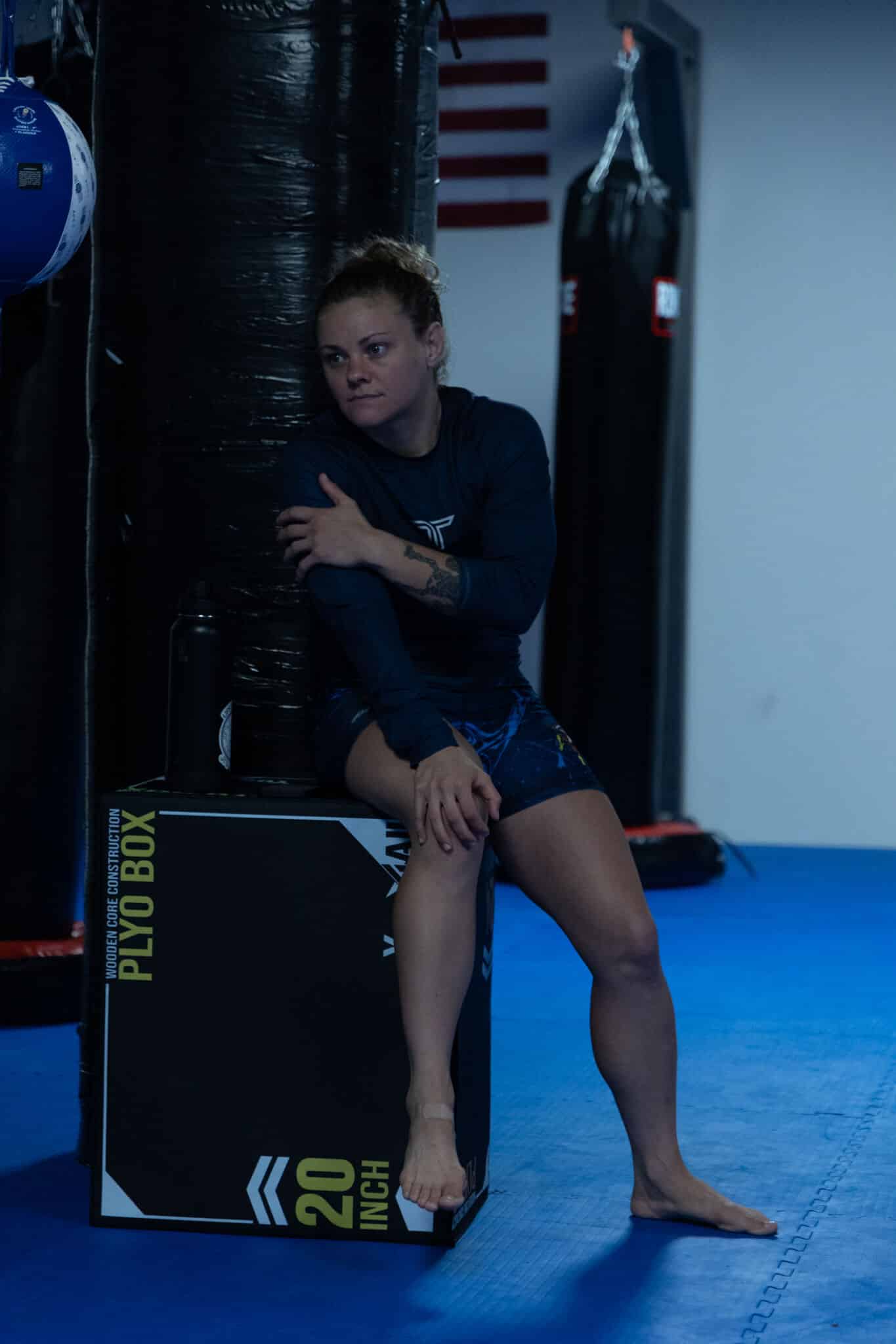 Carlson Gracie Grand Rapids female student sitting on block watching class.