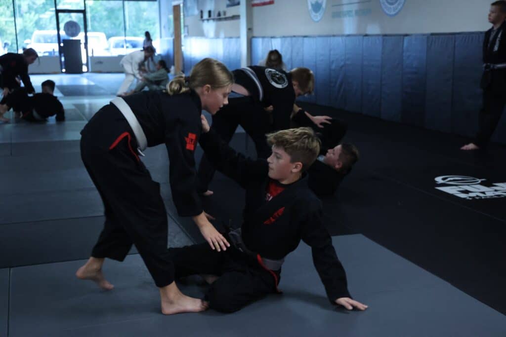 Carlson Gracie Grand Rapids young BJJ students grappling during youth jiu-jitsu class.